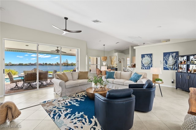 living room featuring ceiling fan, a water view, light tile patterned floors, and vaulted ceiling