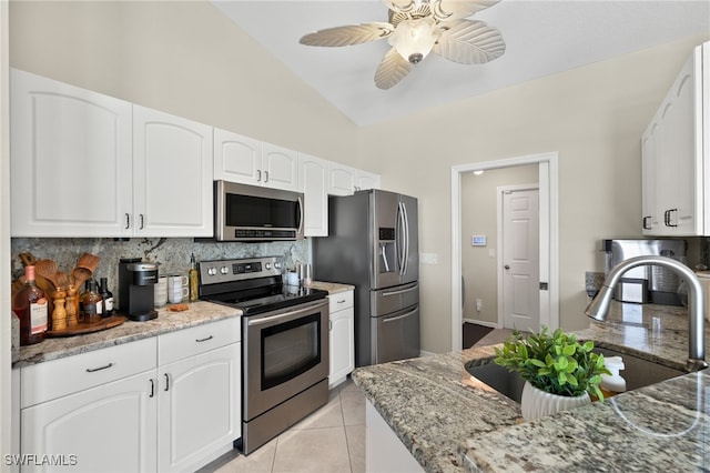 kitchen featuring white cabinets, appliances with stainless steel finishes, light stone counters, and sink