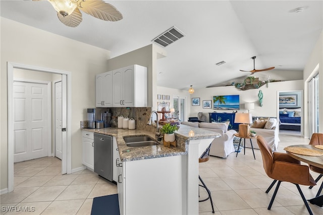 kitchen with dishwasher, sink, light stone countertops, white cabinetry, and a breakfast bar area