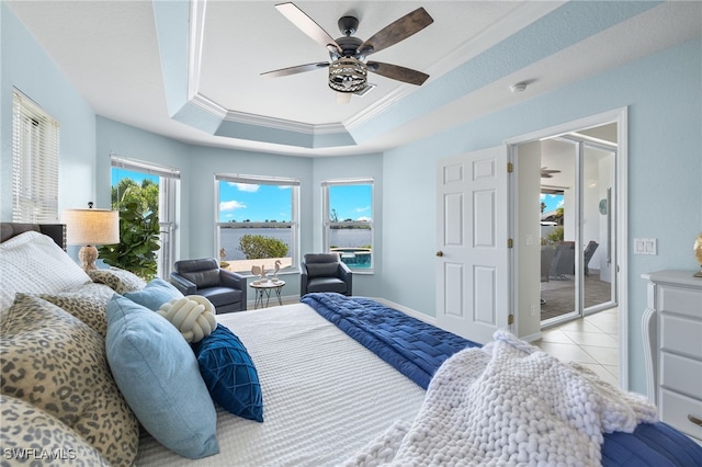 bedroom with ceiling fan, a raised ceiling, light tile patterned floors, and crown molding