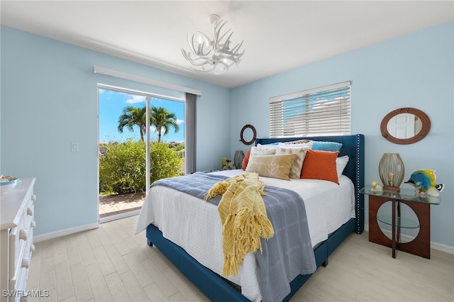 bedroom with access to outside, light hardwood / wood-style floors, and a notable chandelier