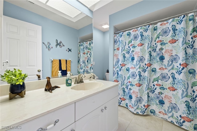 bathroom featuring tile patterned floors, a skylight, and vanity