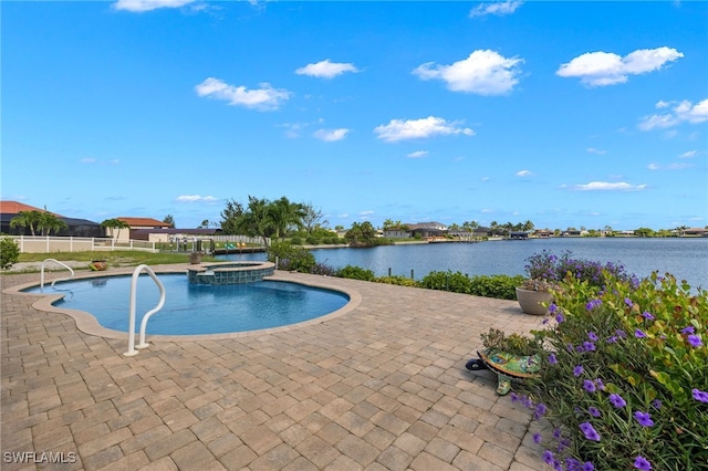 view of pool featuring an in ground hot tub, a water view, and a patio area