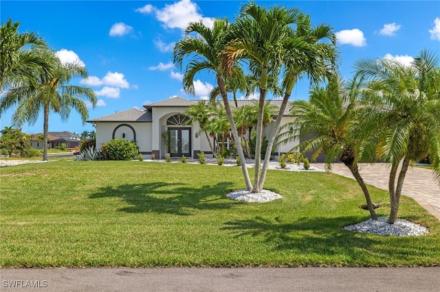 mediterranean / spanish house featuring french doors and a front lawn