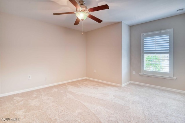 carpeted spare room with ceiling fan