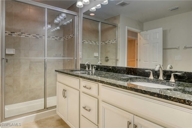 bathroom with tile patterned flooring, vanity, and a shower with shower door