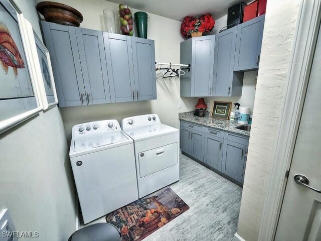 washroom with cabinets, independent washer and dryer, and light wood-type flooring