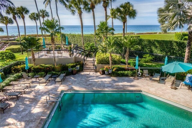 view of pool featuring a patio area and a water view