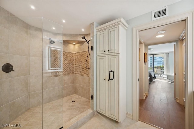 bathroom with a shower with shower door and hardwood / wood-style flooring