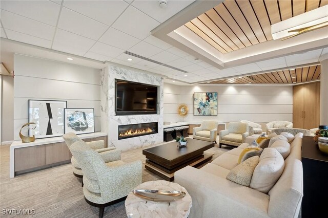 carpeted living room with wooden walls and a high end fireplace