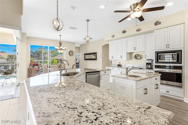 kitchen featuring sink, stainless steel appliances, an island with sink, pendant lighting, and ceiling fan with notable chandelier