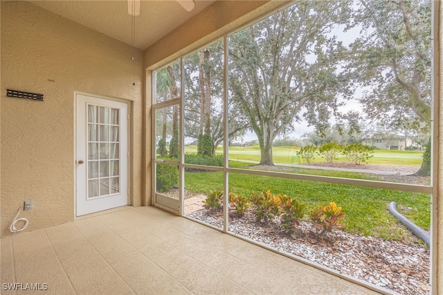 unfurnished sunroom featuring ceiling fan