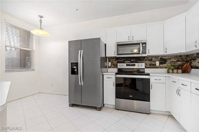 kitchen with pendant lighting, backsplash, stainless steel appliances, and white cabinets