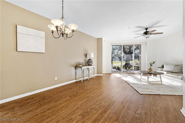 interior space featuring ceiling fan with notable chandelier, a wall of windows, and dark hardwood / wood-style floors