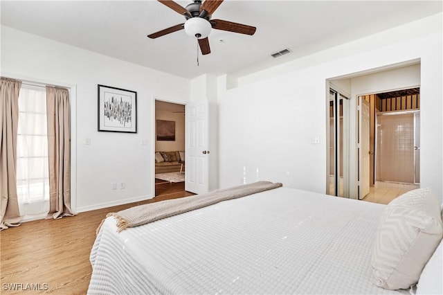 bedroom with connected bathroom, light hardwood / wood-style floors, and ceiling fan