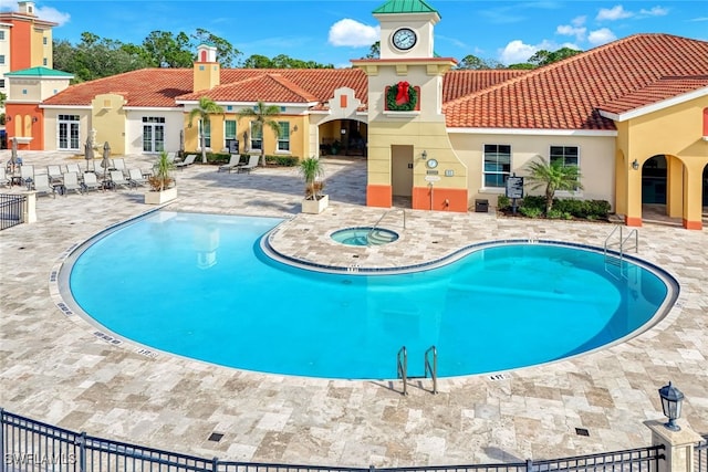 view of pool with a hot tub and a patio area