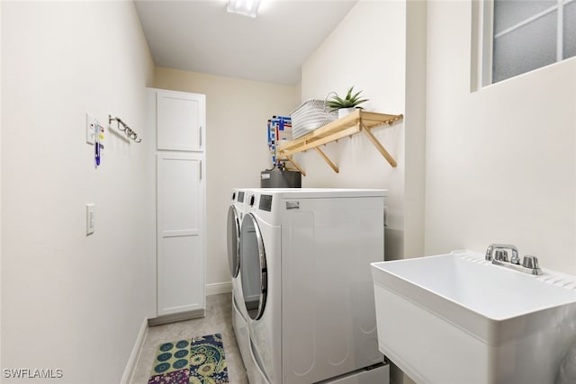 laundry area featuring cabinets, sink, and washing machine and clothes dryer