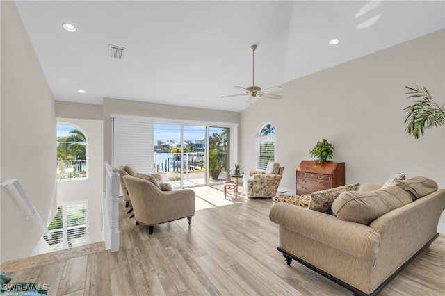 living room with light wood-type flooring, ceiling fan, and lofted ceiling