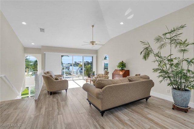 living room featuring ceiling fan, light hardwood / wood-style floors, and lofted ceiling