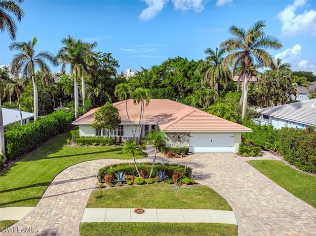 single story home featuring a garage and a front lawn