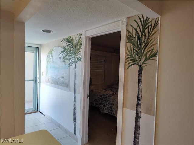 corridor featuring light tile patterned flooring and a textured ceiling