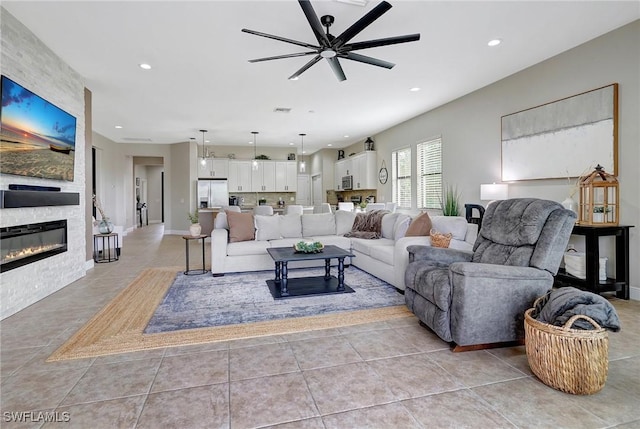 living room with ceiling fan, light tile patterned floors, and a fireplace