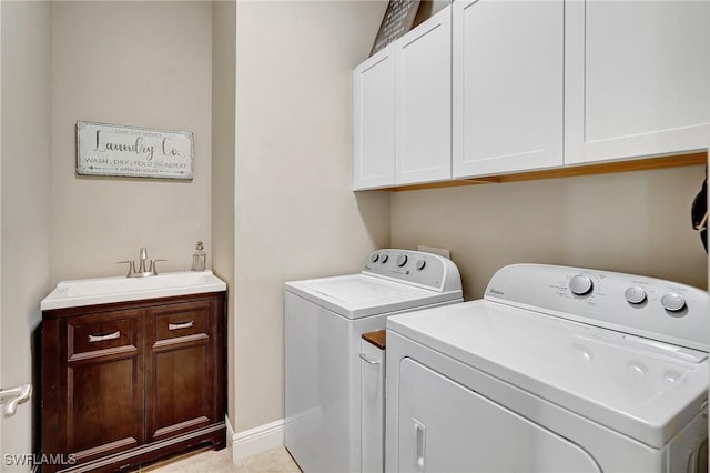 clothes washing area featuring washer and clothes dryer, sink, light tile patterned floors, and cabinets