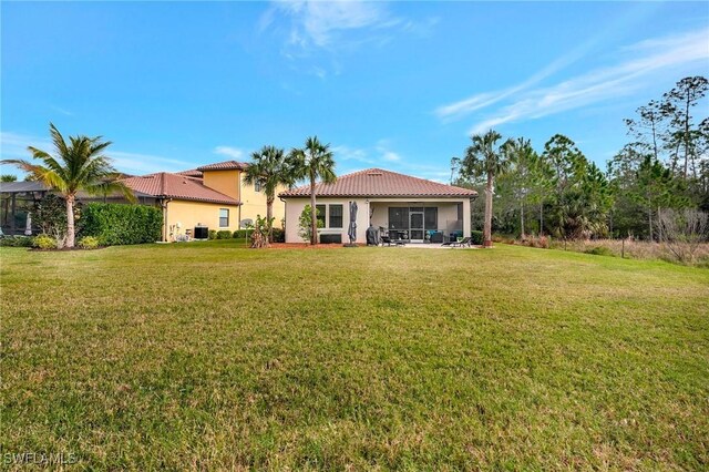 rear view of property with central AC, a patio, and a yard