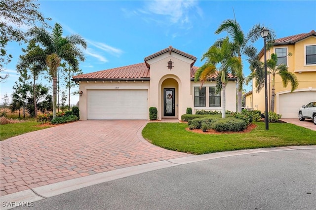 mediterranean / spanish home featuring a front lawn and a garage