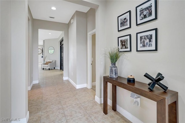 hall featuring recessed lighting, light tile patterned flooring, visible vents, and baseboards