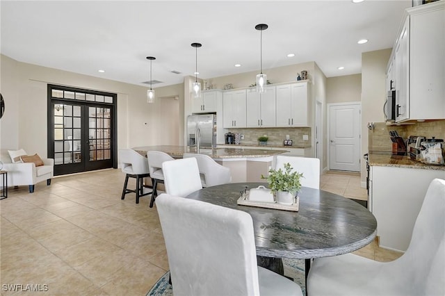 dining area featuring light tile patterned floors and french doors