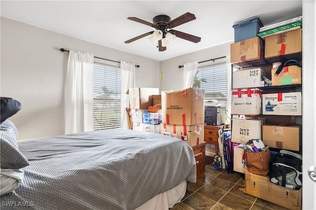 tiled bedroom featuring multiple windows and ceiling fan