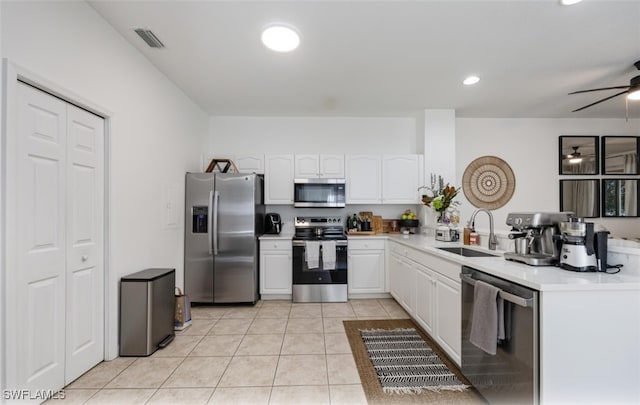 kitchen with white cabinets, light tile patterned floors, sink, and appliances with stainless steel finishes