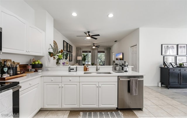 kitchen featuring light tile patterned floors, dishwasher, a peninsula, white cabinetry, and a sink