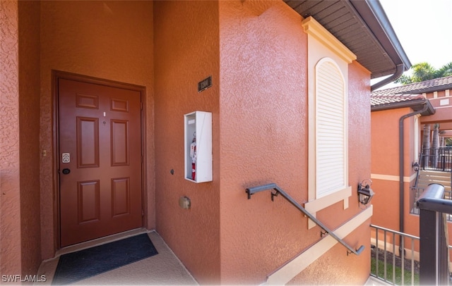 property entrance with stucco siding