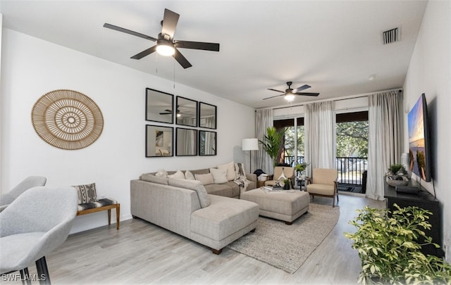 living room with ceiling fan and light wood-type flooring