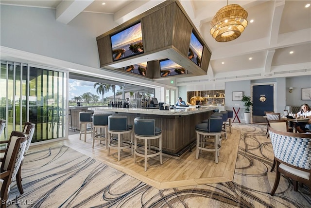 bar featuring a towering ceiling, beam ceiling, and recessed lighting