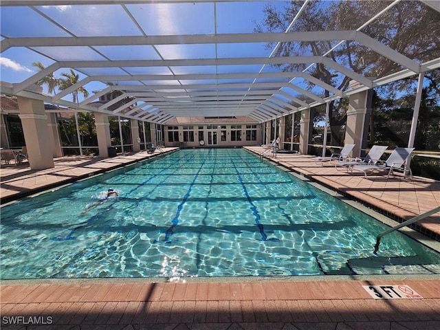 view of swimming pool featuring a patio area and glass enclosure