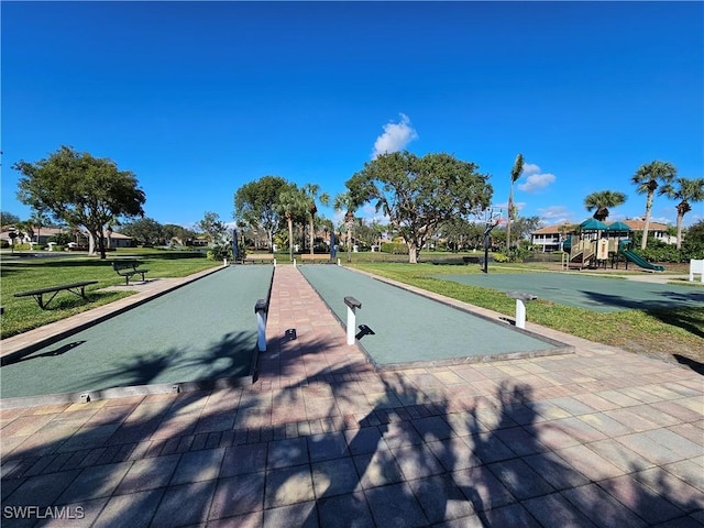 view of property's community featuring a lawn and a playground