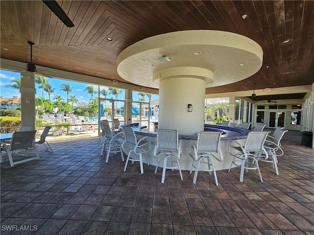 view of patio / terrace featuring a bar and ceiling fan