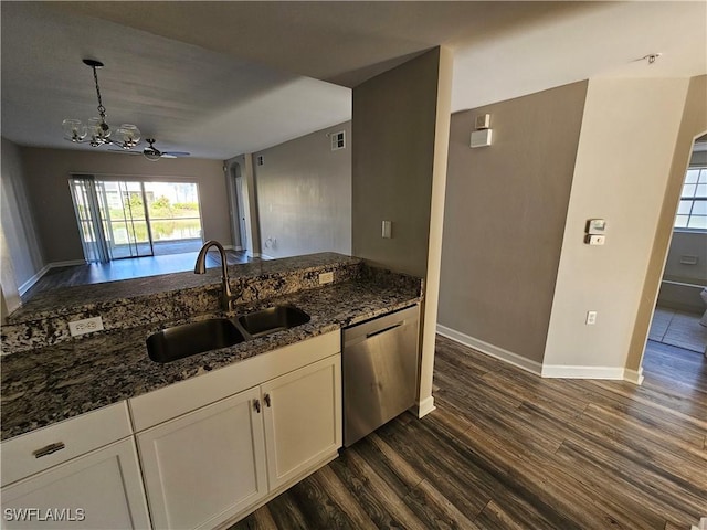 kitchen featuring pendant lighting, sink, dishwasher, white cabinets, and dark stone counters