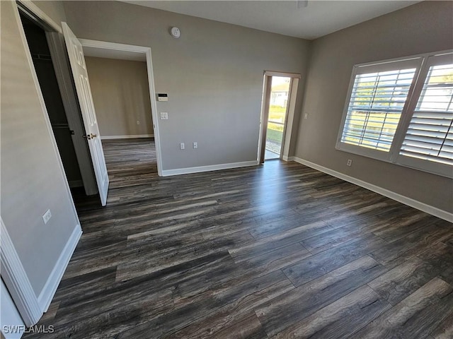 unfurnished room with dark hardwood / wood-style flooring