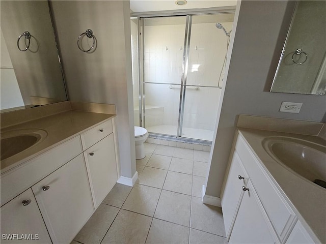 bathroom with tile patterned flooring, vanity, toilet, and a shower with shower door