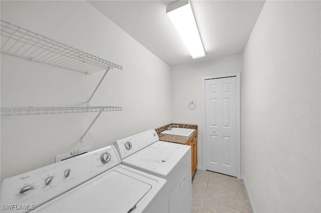 clothes washing area with cabinets, independent washer and dryer, sink, and light tile patterned floors