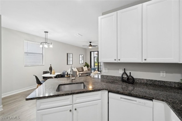 kitchen featuring ceiling fan with notable chandelier, white dishwasher, sink, decorative light fixtures, and white cabinetry