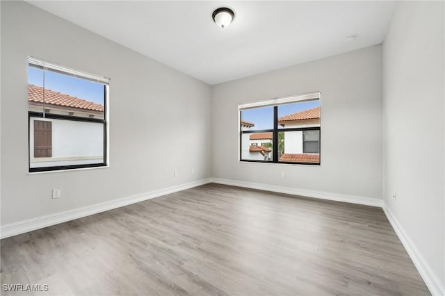 empty room with wood-type flooring and a healthy amount of sunlight