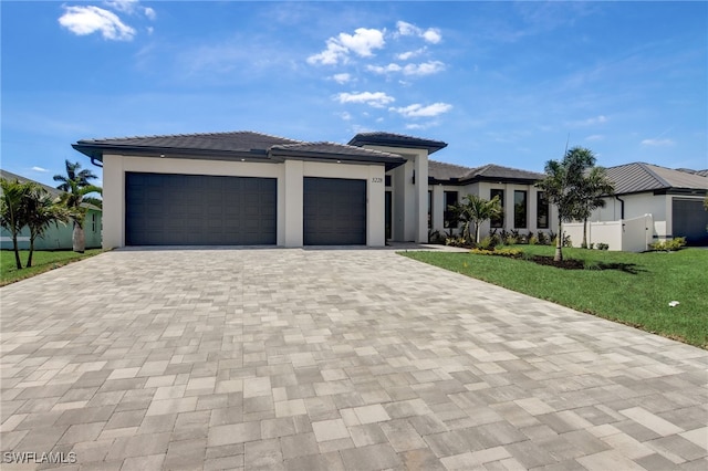 prairie-style home with a garage and a front lawn