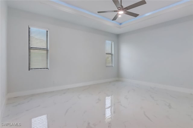 empty room with a tray ceiling and ceiling fan