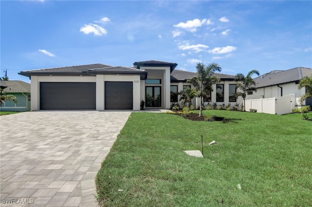 prairie-style home with a front lawn and a garage