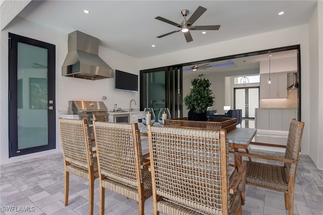 dining area with ceiling fan, sink, and french doors